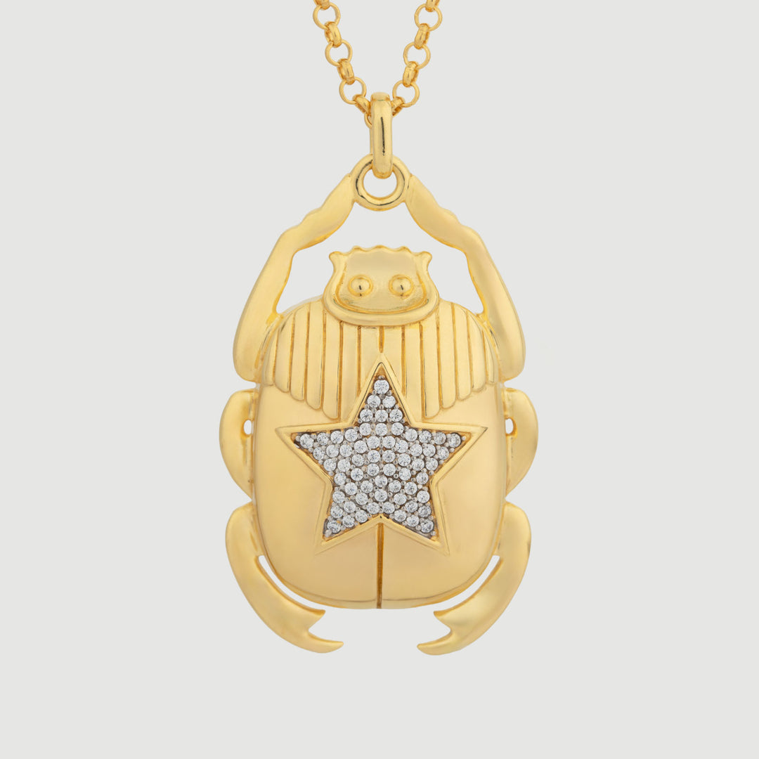 Gold scarab pendant necklace with star design on a light gray background