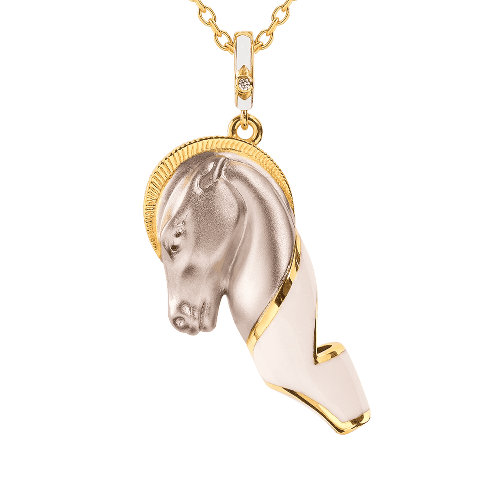 Gold and silver horse head pendant on a chain against a dark background